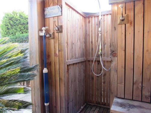 une douche dans un mur en bois avec un tuyau dans l'établissement Villa avec Terrasse, Spa et Proximité Plages - FR-1-194-256, à La Faute-sur-Mer