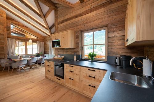 a kitchen with wooden walls and wooden counters at Hotel Dorfer in Grossarl