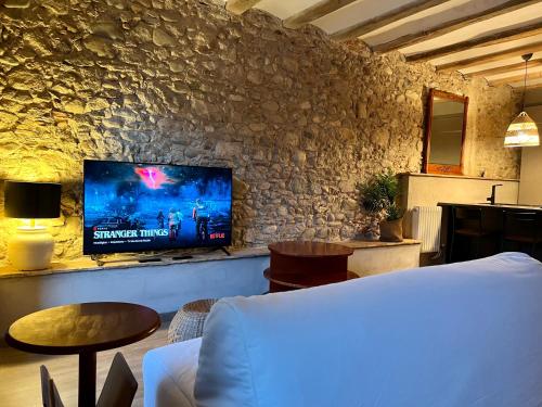sala de estar con TV en una pared de piedra en Precioso Girona largas estancias, en Girona