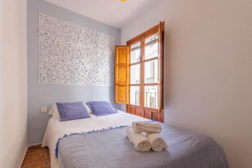 a bedroom with a bed with towels on it at Apartamento Ilusión Andaluza in Córdoba