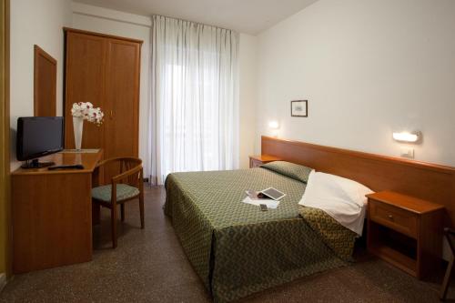 una camera d'albergo con letto e TV di Hotel International a Gabicce Mare