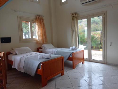 a bedroom with two beds and a window at La Luna Apartments in Stalida