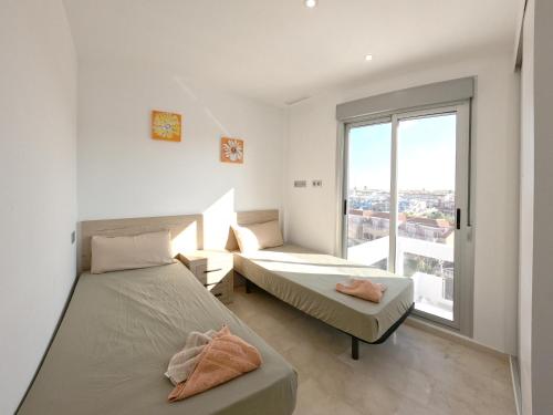 deux lits dans une chambre avec une grande fenêtre dans l'établissement Modern 3 Bedroom 7 Guests Sun Golf Beach Apartments, à Villacosta