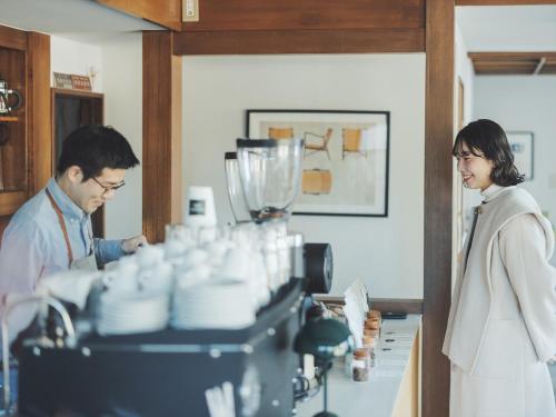 a man and a woman standing behind a machine at SOKI Kanazawa in Kanazawa