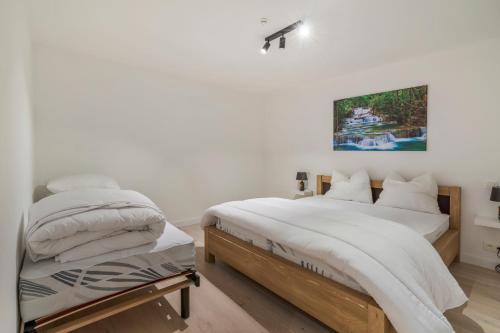 a bedroom with two beds and a painting on the wall at Maison les Bruyères 1 - Luxueus wonen Blankenberge in Blankenberge