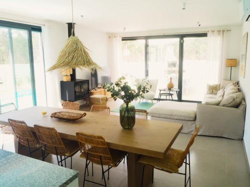 a living room with a table with a vase of flowers at Villa Au Bain Marie in São Martinho do Porto