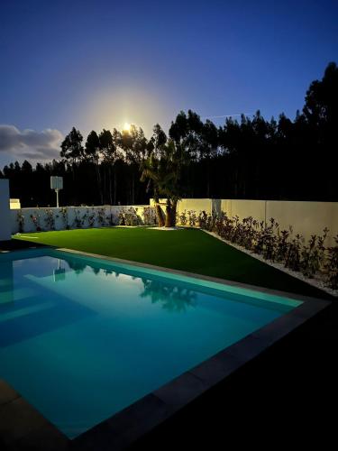 a swimming pool in front of a golf course at Villa Au Bain Marie in São Martinho do Porto