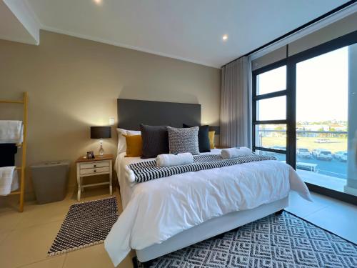 a bedroom with a large bed and a large window at The Pier no. 7 in Swakopmund