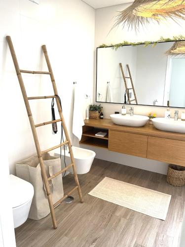 a bathroom with two sinks and a large mirror at Villa Au Bain Marie in São Martinho do Porto