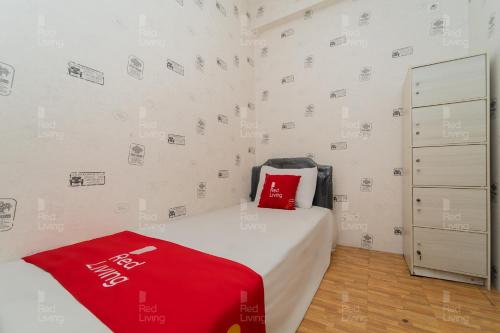 um quarto com uma cama com um cobertor vermelho em RedLiving Apartemen Tamansari Panoramic - Rasya Room with Netflix em Bandung