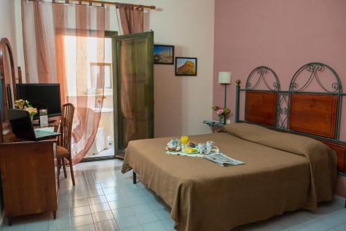 ein Schlafzimmer mit einem Bett und einem Tisch mit Essen darauf in der Unterkunft Grand Hotel Mosè in Villaggio Mosè
