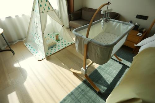 a room with a crib and a baby swing at The Nook Hotel Hangzhou - A design hotel, 20 mins to West Lake and Lingyin Temple in Hangzhou