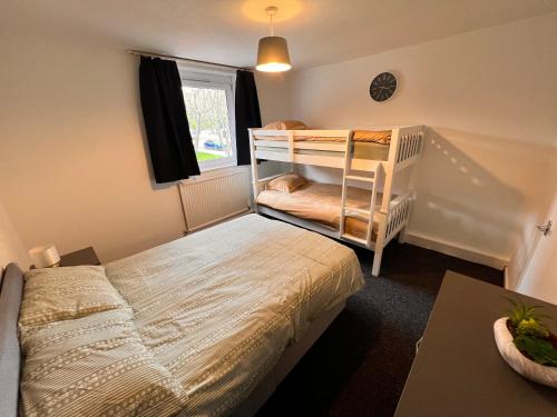 Archway Islington London في لندن: غرفة نوم بسريرين بطابقين وسرير أطفال