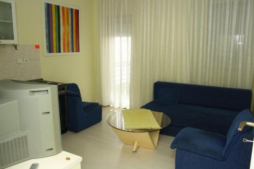 a living room with a blue couch and a table at Villa Greta Pipile in Ohrid