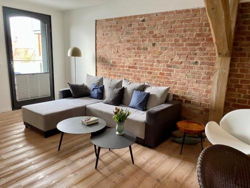 a living room with a couch and a brick wall at Speicher Residenz Barth E3 App 11 in Barth
