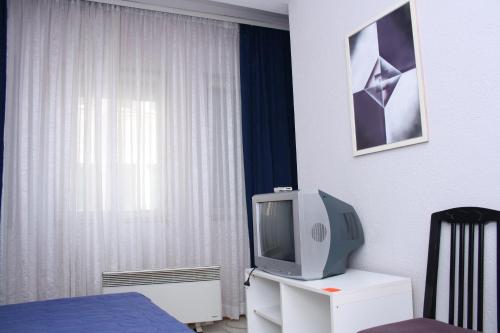 - une chambre avec une télévision sur une commode et un lit dans l'établissement Villa Greta Pipile, à Ohrid