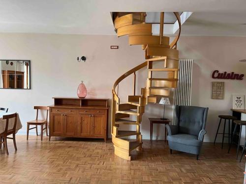 una escalera de caracol de madera en una sala de estar con silla en Este Stay, en Este