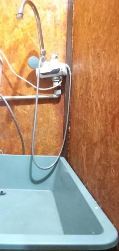 La salle de bains est pourvue d'un pommeau de douche sur un mur. dans l'établissement Невелике помешкання зі зручностями та парковкою, à Tcherkassy