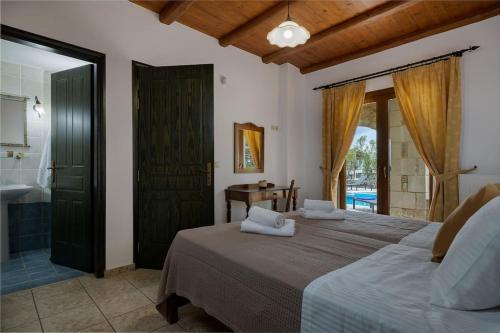 een slaapkamer met een bed en een badkamer met een bad bij Villa Stefania/pool/garden/sea view/3bdrms/3bthrms in Agia Marina Nea Kydonias