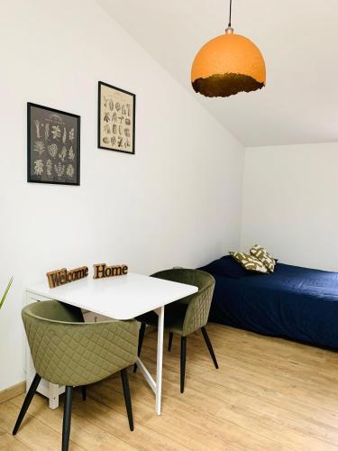 une pièce avec une table, des chaises et un lit dans l'établissement Le Studio d'Emy, à Tiffauges