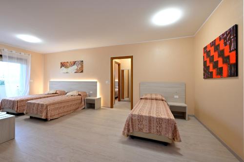 a hotel room with two beds and a hallway at Hotel Italia in Monfalcone