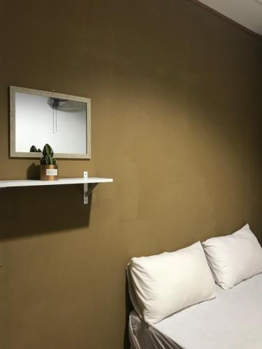 a room with a bed and a shelf and a mirror at Nusantara Mattwaddien Hostel in Kota Kinabalu