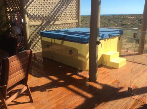 a hot tub on a deck with a bench at On the Deck @ Shark Bay in Denham