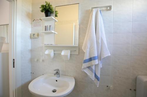 y baño con lavabo y espejo. en Hotel Villa Gioiosa en Rímini