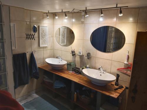 a bathroom with two sinks and two mirrors at Bølshavnvej5 Bed & Breakfast in Svaneke