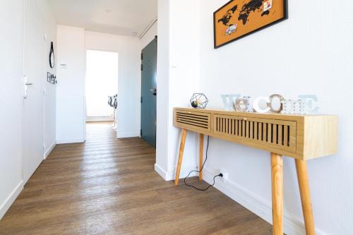 un couloir avec une table en bois sur un mur dans l'établissement Oasis urbaine - proche centre-ville - garage, à Amiens