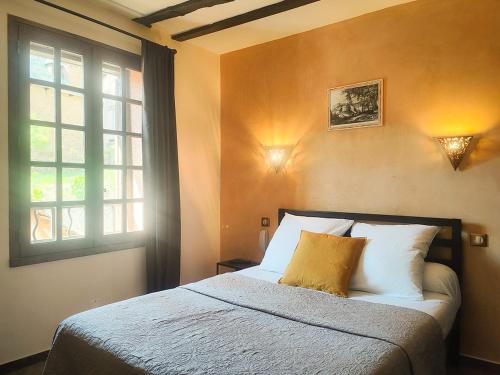 a bedroom with a bed and a window at Auberge Saint Jacques in Conques