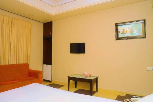 Habitación con cama, sofá y mesa. en Royal Living Hotel & Suites, en Chittagong