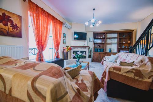 Villa Olga Sea Front Katakolo - Happy Rentals في كاتاكولو: غرفة معيشة بها سريرين وأريكة