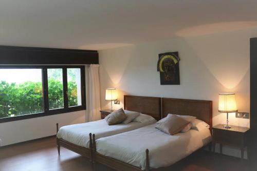 1 dormitorio con 2 camas y ventana grande en Casa Rural Finca San Lorenzo, en Prado