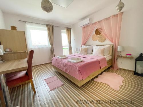 a bedroom with a pink bed with a pink canopy at Zen House in Hajdúszoboszló