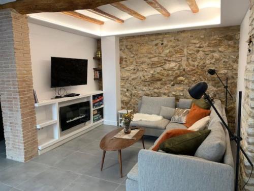 a living room with a couch and a tv at Casa Valleta in Tivenys