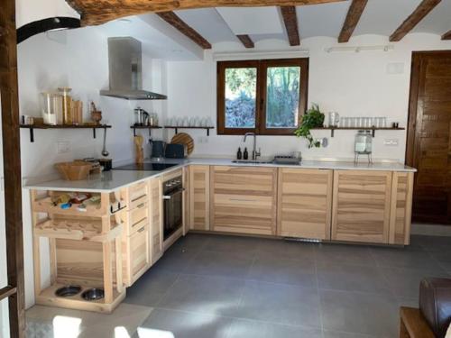 a kitchen with wooden cabinets and a counter top at Casa Valleta in Tivenys