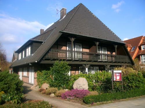 a large wooden house with a black roof at Landhaus Zum Heidewanderer in Bad Bevensen