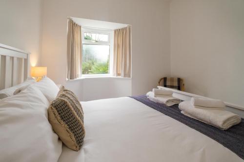 a white bed in a room with a window at The Lodge, Aldringham in Aldringham