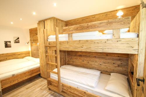 2 literas en una habitación con paredes de madera en Ferienwohnung Königsleiten 28 - Top 36, en Wald im Pinzgau