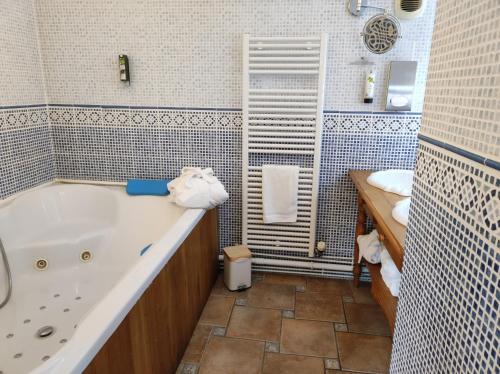 a bathroom with a tub and a toilet and a sink at Le Relais Des Dalles in Sassetot-le-Mauconduit
