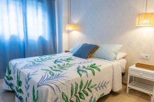 a bedroom with a bed with a blue and white blanket at Apartamento mediterráneo en pleno corazón de Moraira in Moraira