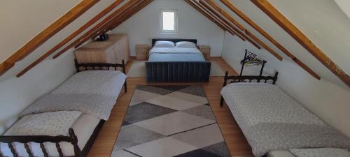 a attic room with three beds and a table at Getaway house Loko in Trebinje