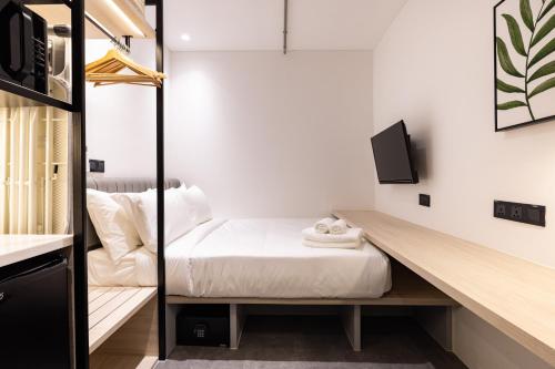 um pequeno quarto com uma cama e uma secretária em Heritage Collection on Pagoda - A Digital Hotel em Singapura