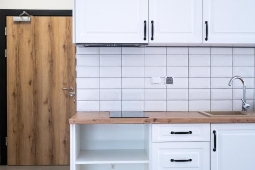 a kitchen with white cabinets and a sink at Zajazd Tadeo in Pietrzykowice