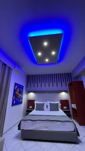 a bedroom with a large bed with a blue ceiling at PREMIUM SUITES in Ofrínion