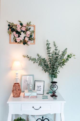 a white table with a vase of flowers on it at City Inn Szigetvar in Szigetvár