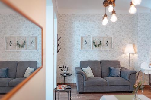 two views of a living room with a couch at City Inn Szigetvar in Szigetvár