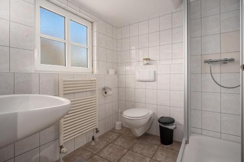 a white bathroom with a sink and a toilet at Deichhus Nordseeliebe direkt am Deich - Nordsee - Dagebüll - Am Vogelreservat in Dagebüll