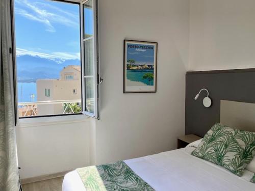 a bedroom with a bed and a large window at Hotel Belvedere in Calvi